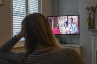Georgia watches the Duke and Duchess of Sussex's controversial documentary being aired on Netflix at her home in Warwick, Britain, Thursday, Dec. 8, 2022. Britain’s monarchy is bracing for more bombshells to be lobbed over the palace gates as Netflix releases the first three episodes of a new series. The show “Harry & Meghan” promises to tell the “full truth” about Prince Harry and his wife Meghan’s estrangement from the royal family. The series debuted Thursday. (Jacob King/PA via AP)