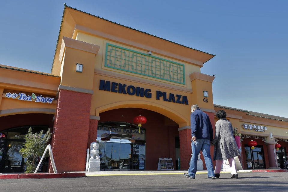 In this Feb. 13, 2020, photo, patrons enter Mekong Plaza in the Asian district, in Mesa, Ariz. Arizona's freshly crowned Asian District was deep into organizing its night market when news broke that a case of the illness known as COVID-19 was confirmed at nearby Arizona State University. Xenophobic comments on social media and phone calls started almost immediately, according to Arizona Asian Chamber of Commerce CEO Vicente Reid. (AP Photo/Matt York)