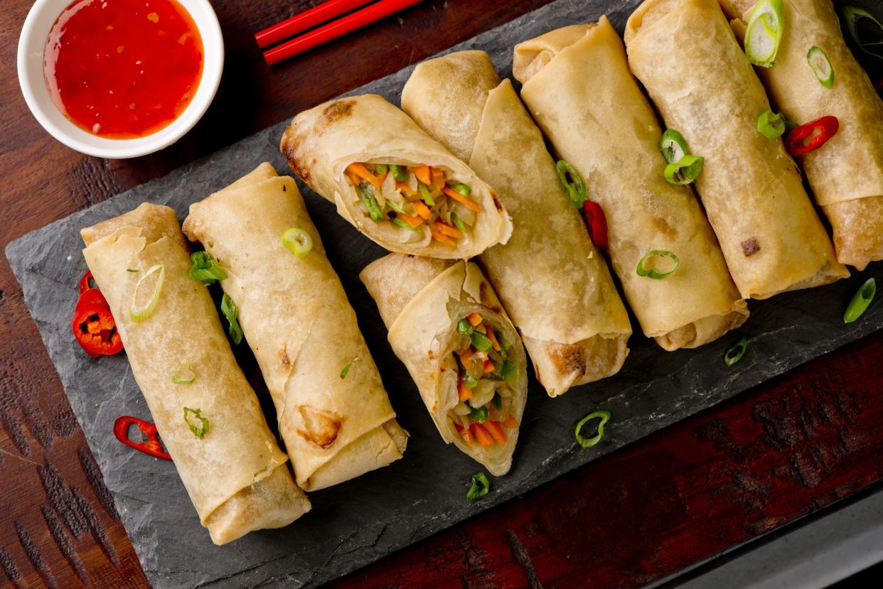 Egg rolls or spring rolls fried.Traditional Chinese Thai restaurant appetizer, spring rolls or egg rolls. Made from wonton wrappers and filled with Chinese veggies and served w/ chili dipping sauce.