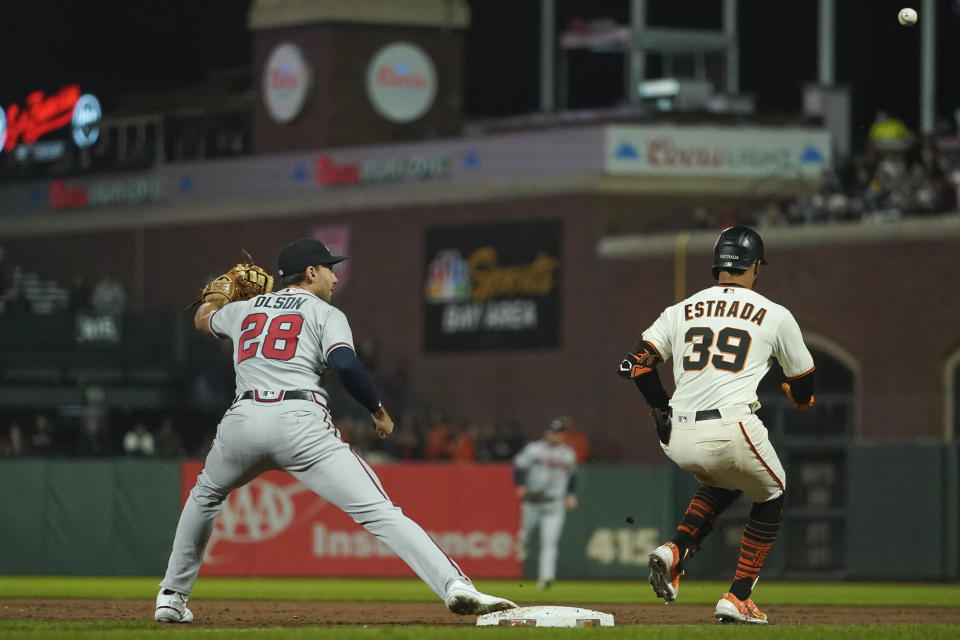 Atlanta Braves first baseman Matt Olson (28) is unable to catch a throw from second baseman Vaughn Grissom as San Francisco Giants' Thairo Estrada (39), who singled, reached first safely on the throwing error during the fifth inning of a baseball game in San Francisco, Monday, Sept. 12, 2022. Giants' Mike Yastrzemski scored on the play. (AP Photo/Godofredo A. Vásquez)