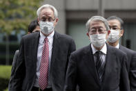 Former Nissan Motor Co. executive Greg Kelly, left, arrives for the first trial hearing at the Tokyo District Court in Tokyo Tuesday, Sept. 15, 2020. The financial misconduct trial of Kelly opened Tuesday. Japanese prosecutors outlined allegations of what they said was a complex and clandestine scheme to pay former star executive Carlos Ghosn. (Kiyoshi Ota/Pool Photo via AP)