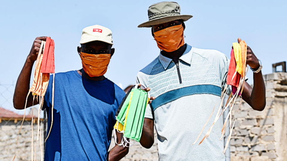 Hombres sosteniendo mascarillas en el municipio de Nkowankowa, Sudáfrica.