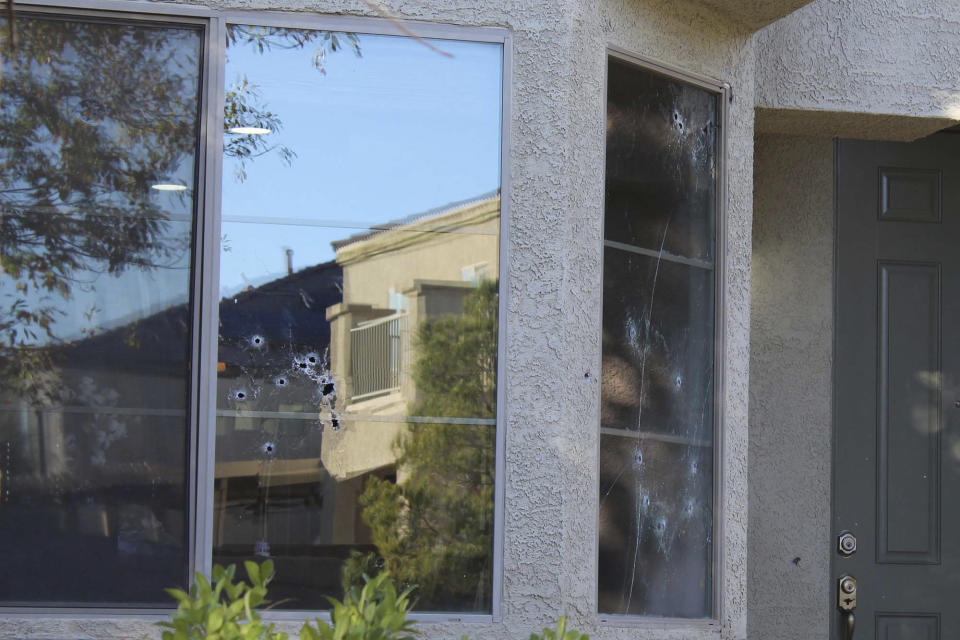 Bullet holes mark the windows of a house that was hit by gunfire Thursday night, killing an 11-year-old girl in North Las Vegas, Friday, Nov. 2, 2018. An armed group intent on gang-related retaliation opened fire on the wrong house in suburban Las Vegas, killing the girl in her kitchen, police said Friday. (Max Michor/Las Vegas Review-Journal via AP)