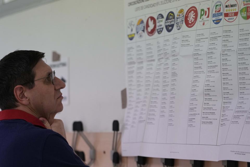 Un hombre revisa un cartel electoral en un centro de votación en Milán, Italia, el sábado 8 de junio de 2024. (AP Foto/Luca Bruno)