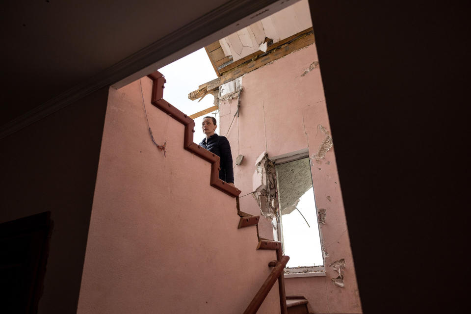 Oksana ascends a staircase in her family's home in Hostomel, Ukraine, on April 25, 2022.