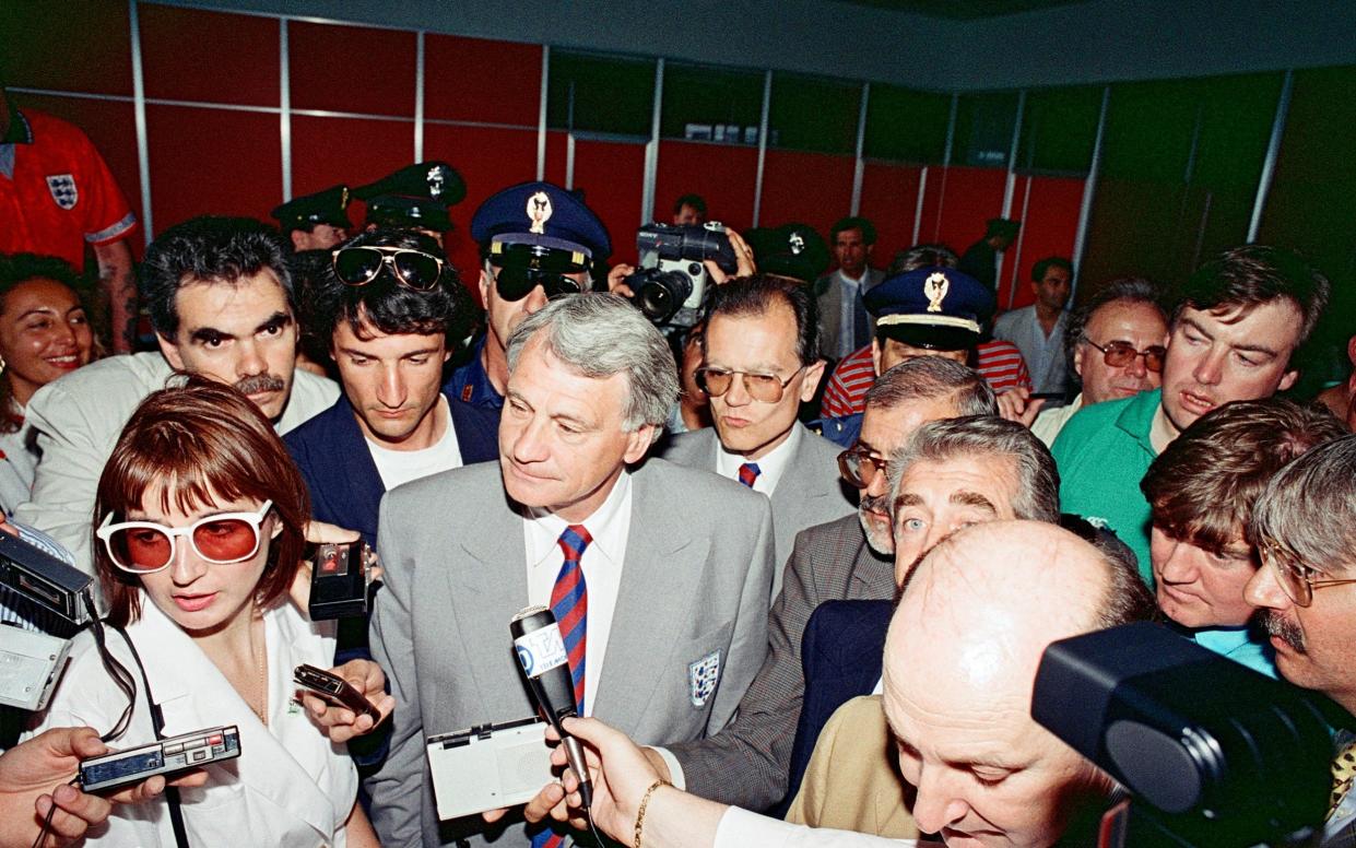 England manager Bobby Robson surrounded by reporters at the airport, circa June 1990. The 1990 FIFA World Cup Finals in Italy