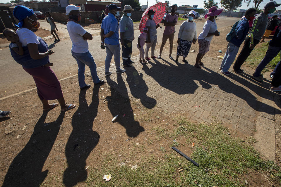 People queue outside a polling station in Thokoza, east of Johannesburg, Monday, Nov. 1, 2021. South Africa is holding crucial local elections Monday. (AP Photo/Themba Hadebe)