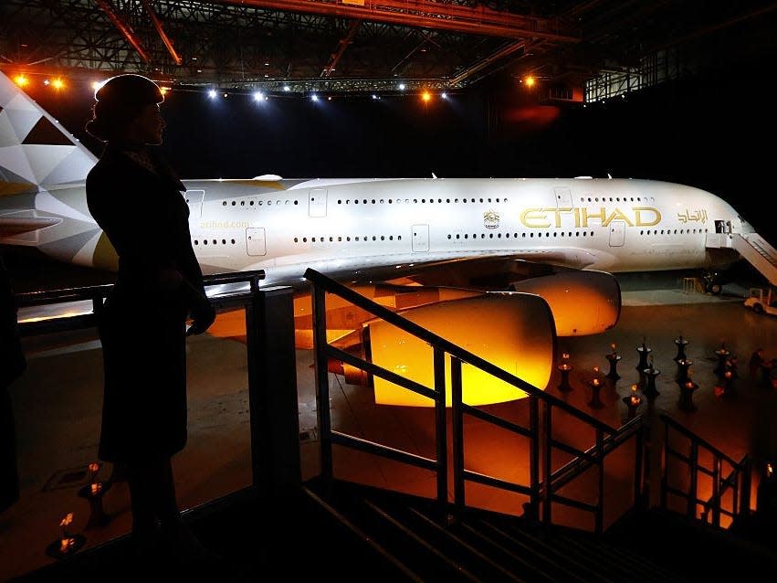 Etihad A380 with flight attendant standing in front.