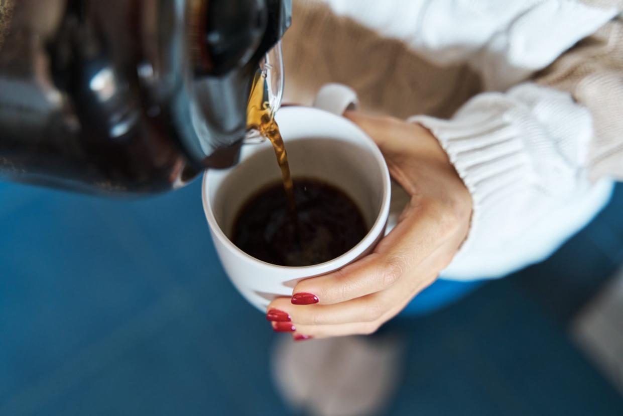 woman pouring coffee into coffee mug