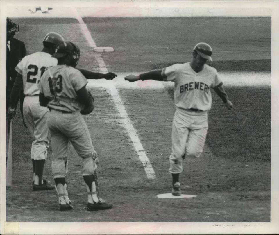 Skip Lockwood crossed home after belting a home run in the sixth inning of the second game of a doubleheader at County Stadium on May 10, 1970. Milwaukee's Tommy Harper (21) awaited Lockwood at the plate along with Washington Senators catcher John Roseboro.