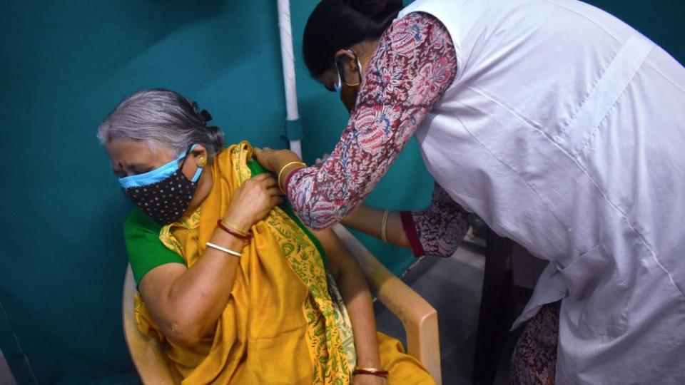 A woman receives a dose of COVISHIELD, a coronavirus disease (COVID-19) vaccine at a Kolkata Municipality medical centre in Kolkata.