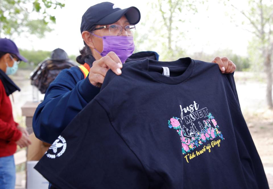 Arlene Pioche, substance abuse program specialist at Northern Navajo Medical center, shows this year's Just Move It T-shirt to participants on May 11 at Berg Park in Farmington.