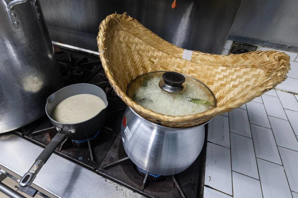 La mezcla de leche de coco se calienta en la estufa junto al arroz glutinoso que se cocina en un 'Thip Khao' para el arroz que se sirve con la salchicha de Laos y el mango con arroz glutinoso. La frase thip khao se refiere a una canasta para cocinar al vapor arroz glutinoso que se usa comúnmente en Laos y en las comunidades de la diáspora.