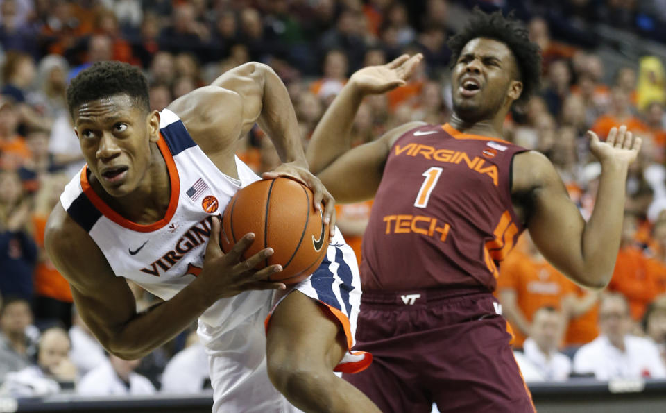 Virginia guard De'Andre Hunter (12) drives top the basket as he gets around Virginia Tech guard Isaiah Wilkins (1) during the first half of an NCAA college basketball game in Charlottesville, Va., Tuesday, Jan. 15, 2019. (AP Photo/Steve Helber)