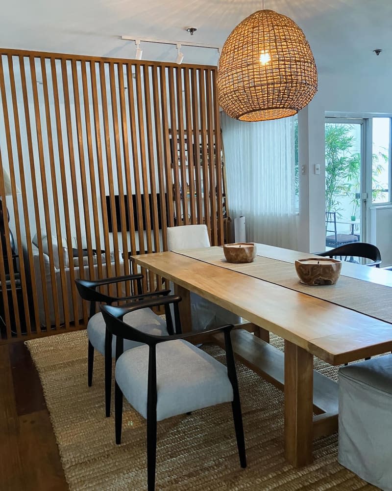 Pendant hung above wooden rectangular dining table.