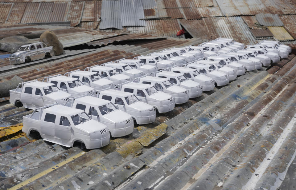 Small cars made by inmates to sell at the Alasita fair dry on the roof of the San Pedro jail for men in La Paz, Bolivia, Bolivia, Jan. 18, 2024. The annual fair, which starts Jan. 24, is a pre-Columbian event where people buy tiny replicas of things they dream of owning. (AP Photo/Juan Karita)