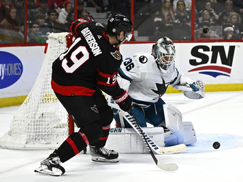 San Jose Sharks goaltender Kaapo Kahkonen (36) watches the puck in front of Ottawa Senators right wing Drake Batherson (19) during the second period of an NHL hockey game Saturday, Dec. 3, 2022, in Ottawa, Ontario. (Justin Tang/The Canadian Press via AP)