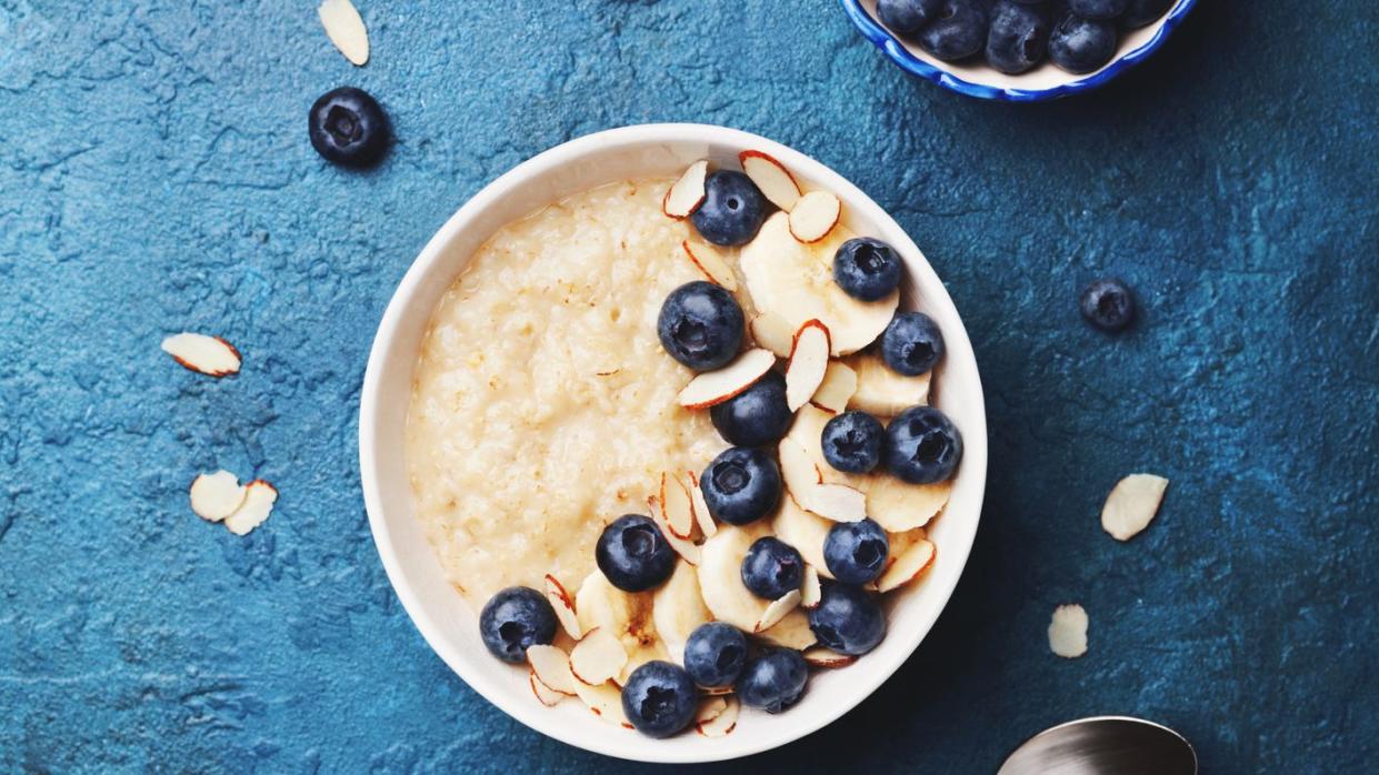 oatmeal porridge with banana and blueberry on vintage table top view in flat lay style