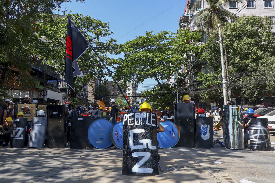 Anti-coup protesters take cover behind makeshift shields during a demonstration in Yangon, Myanmar Thursday, March 4, 2021. Demonstrators in Myanmar protesting last month's military coup returned to the streets Thursday, undaunted by the killing of at least 38 people the previous day by security forces. (AP Photo)