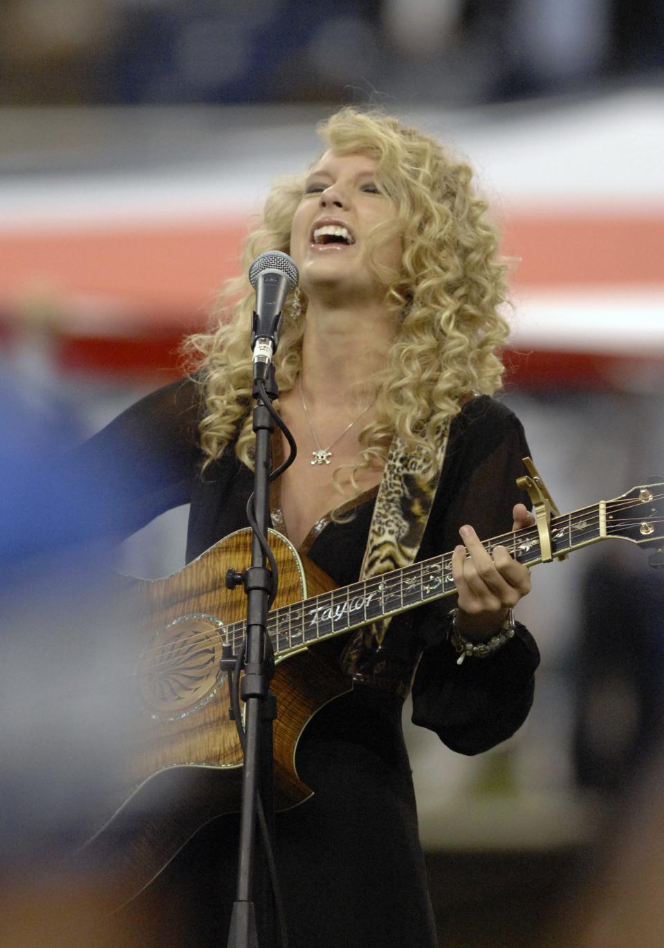 Taylor Swift sings the National Anthem as the Detroit Lions host the Miami Dolphins in a Thanksgiving Day game Nov. 23, 2006 in Detroit.