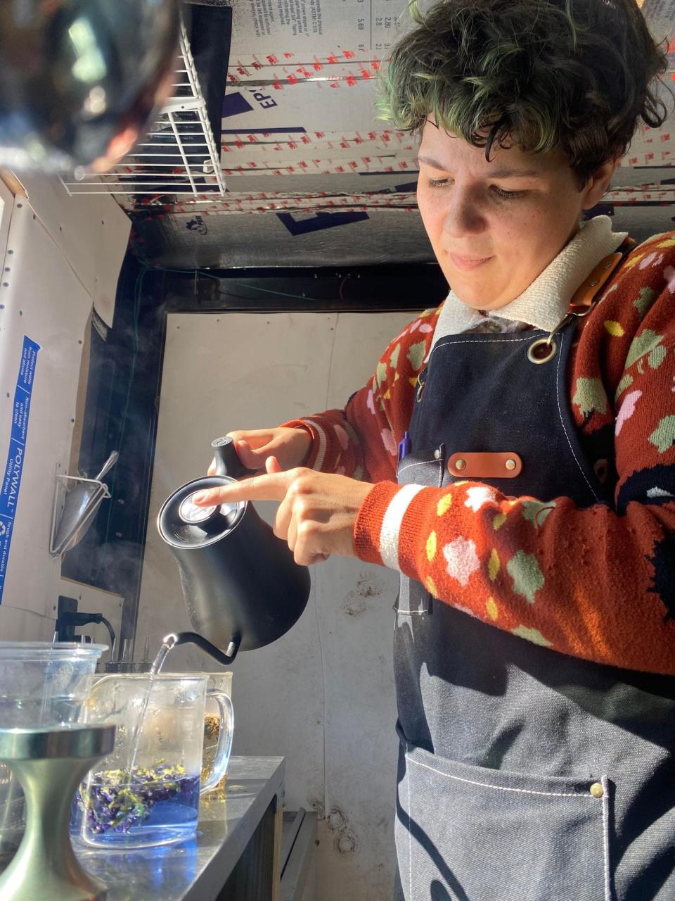 Liv Brandt prepares a colorful butterfly pea tea aboard the Second Wind Beverages & Snacks trailer on Nov. 24.