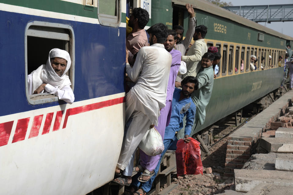 People ride on an overcrowded passenger train to reach their villages and cities to celebrate the upcoming Eid al-Fitr holidays, marking the end of the Islamic holy month of Ramadan, in Lahore, Pakistan, Thursday, April 20, 2023. (AP Photo/K.M. Chaudary)