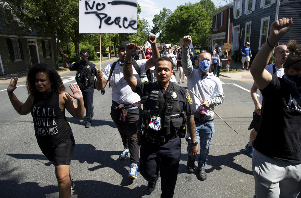 In Fredericksburg, Virginia, police officers, including Uyurre Brown-Kaleopaa, center, join protesters in a June 2 march. Black officers find themselves torn between two worlds when it comes to the protests against police brutality happening around the U.S. (Photo: Mike Morones/The Free Lance-Star via Associated Press)