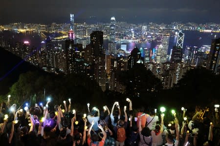 Anti-extradition bill protesters hold hands up to form a human chain during a rally to call for political reforms in Hong Kong