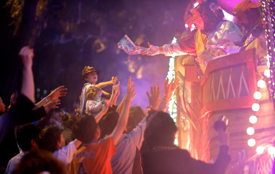 Revelers reach for beads being thrown from floats during the Krewe of Proteus Mardi Gras parade in New Orleans, Monday, Feb. 16, 2015. Proteus initially quit parading when the City Council passed an ordinance in the early 1990s requiring krewes to show that they were racially integrated to obtain a parade permit. After several years, and after the ordinance had been softened, Proteus returned to the streets. (AP Photo/Gerald Herbert)