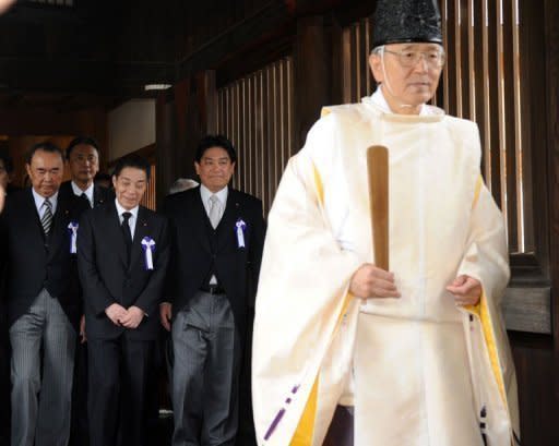 El ministro de Transporte de Japón, Yuichiro Hata (3º izq), y varios legisladores siguen a un sacerdote sintoísta en el santuario de Yasukuni, en Tokio, este miércoles 14 de agosto. (AFP | Yoshikazu Tsuno)