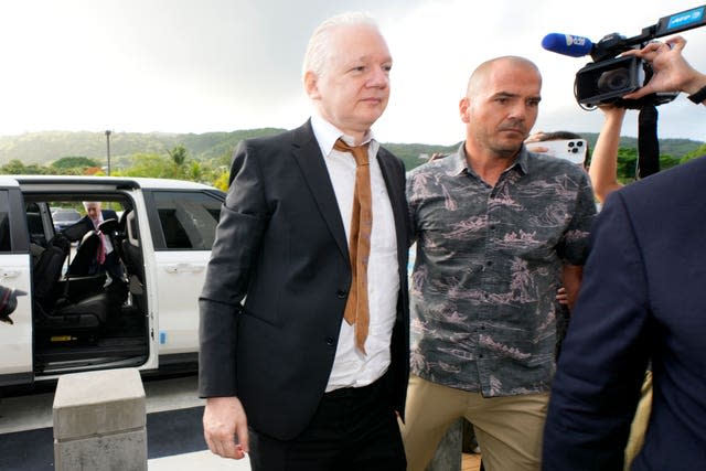 WikiLeaks founder Julian Assange, left, is escorted as he arrives at the United States courthouse, in Saipan, Mariana Islands, Wednesday, June 26 2024.