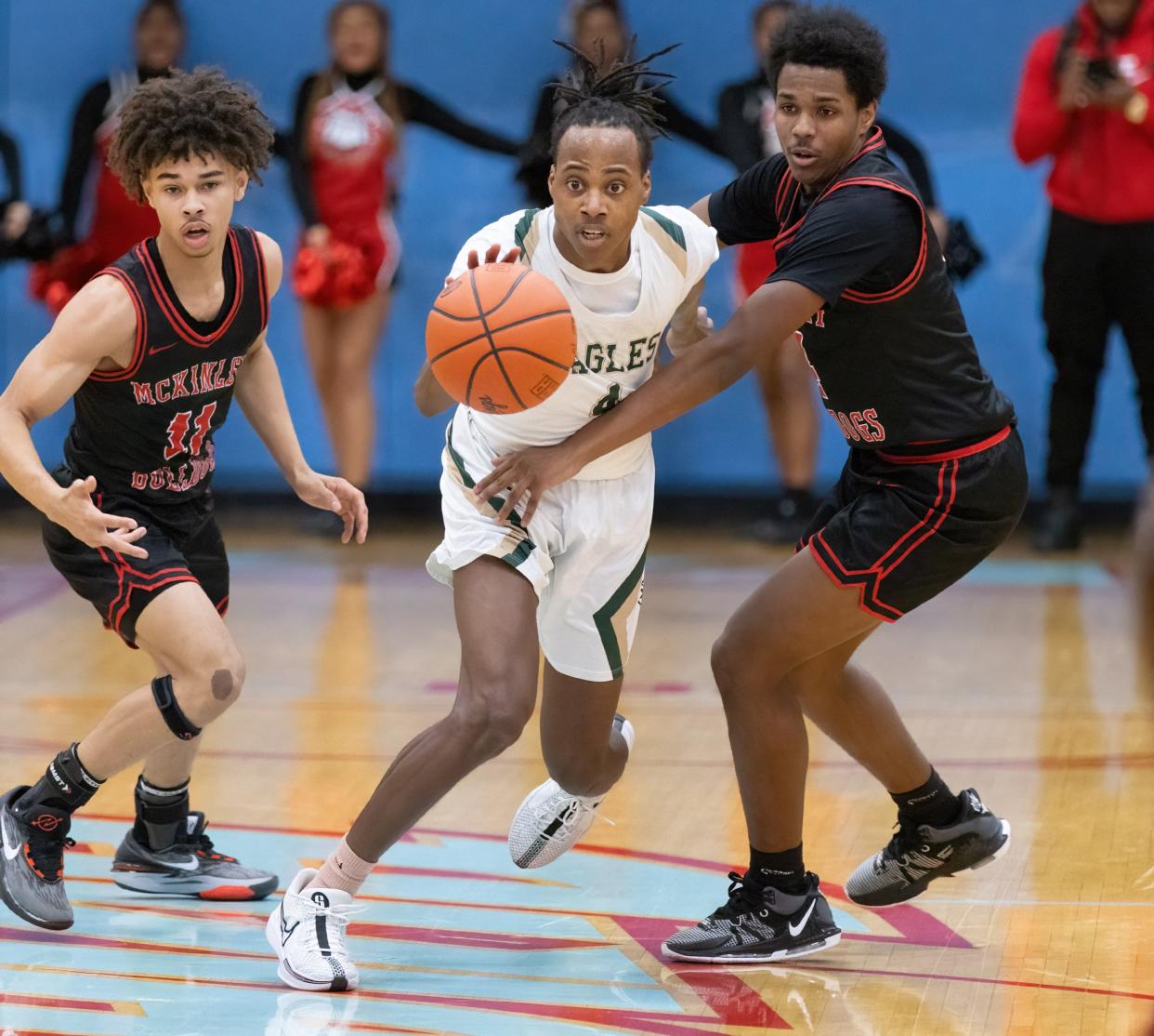 GlenOak’s Jaylen McElroy brings the ball down court between McKinley’s Davey Thompson (left) and Rob Brown during a district semifinal, Thursday, March 7, 2024.