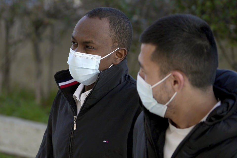 Mohamad Hanad Abdi from Somalia, left, arrives at a court in Mytilene, on the northeastern Aegean island of Lesbos, Greece, Monday, Jan. 9, 2023. The Somali migrant serving life in prison for people smuggling appeared in court Monday to appeal his sentence, in a case backed by a group of European Parliament members who say he was wrongfully convicted. Mohamad Hanad Abdi was sentenced to 142 years in prison in 2021, convicted following a deadly crossing in a dinghy from Turkey to the nearby Greek island of Lesbos the previous year. (AP Photo/Panagiotis Balaskas)