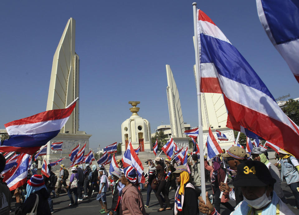 Anti-government protesters holding national flags gather for a rally in front of Democracy Monument, Wednesday, Jan. 15, 2014, in Bangkok, Thailand. Gunshots rang out in the heart of Thailand's capital overnight in an apparent attack on anti-government protesters early Wednesday that wounded at least two people and ratcheted up tensions in Thailand's deepening political crisis.(AP Photo/Sakchai Lalit)