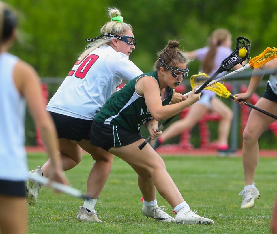 Ursuline's Isabella Tesche (20) defends as Archmere's Bella Hughes tries to maneuver toward the Ursuline net in the Auks' 13-11 win in a visit to Serviam Field, Friday, May 5, 2023.