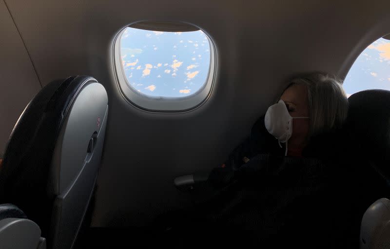 A woman wears a protective mask in response to the spreading of coronavirus (COVID-19), during a flight between Caracas Venezuela and la Havana, Cuba