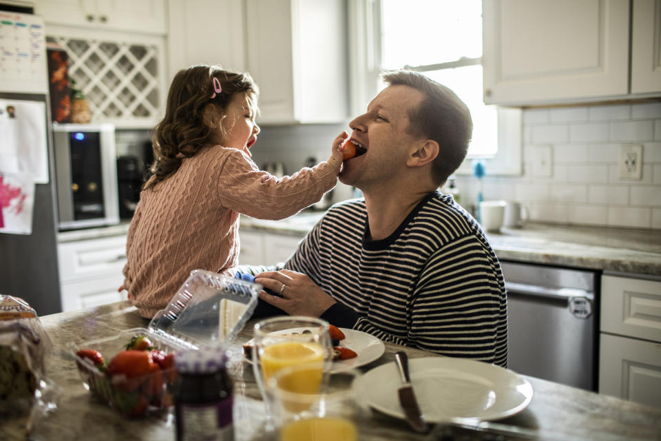 kid feeding their dad strawberries