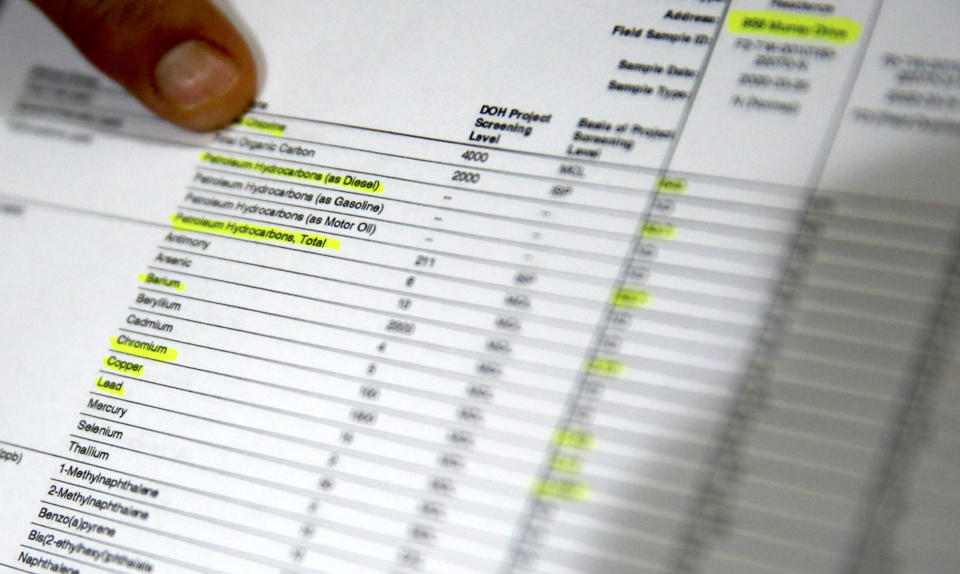 Lauren Wright, a Navy spouse whose family was sickened by jet fuel in their tap water, looks over water test results at her home in Honolulu, Friday, July 1, 2022. A Navy investigation says shoddy management and human error caused fuel to leak into Pearl Harbor's tap water last year. The leak poisoned thousands of people and forced military families to evacuate their homes for hotels. (AP Photo/Caleb Jones)