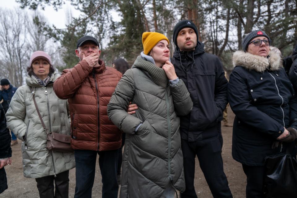 People watch as emergency workers continue to search the remains of a residential building that was struck by a Russian missile Saturday on January 16, 2023 in Dnipro, Ukraine.