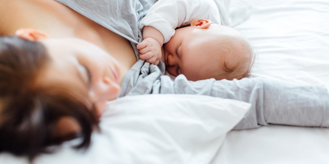 mom in bed nursing baby - postpartum rest