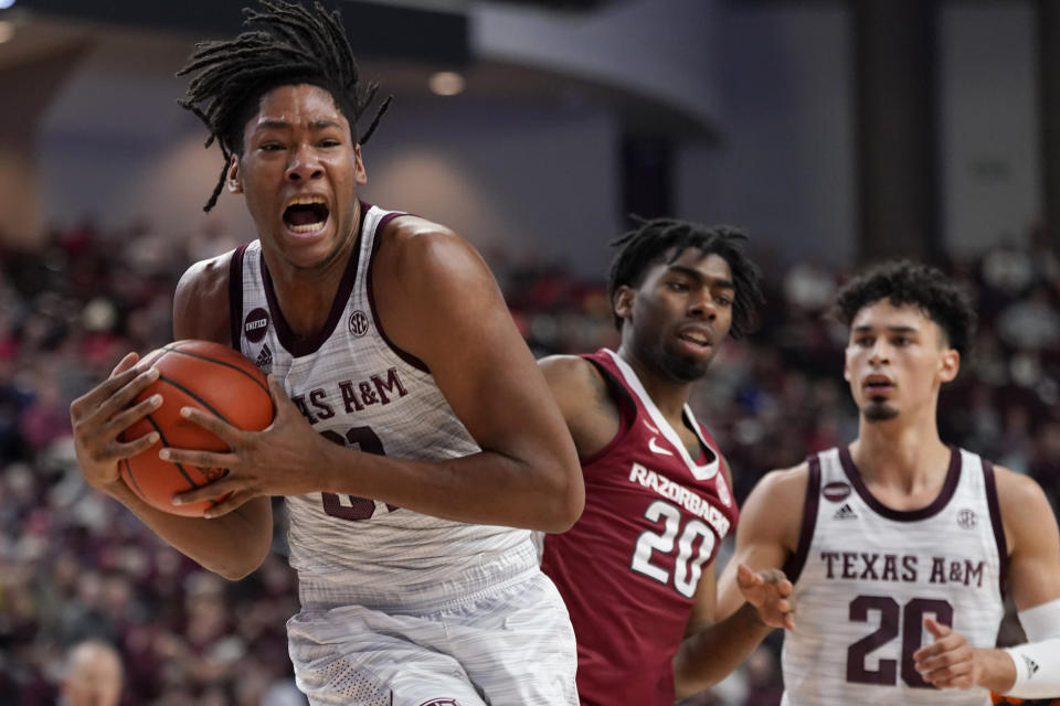 Texas A&M forward Javonte Brown (31) strips the ball away from Arkansas forward Kamani Johnson (20) during the first half of an NCAA college basketball game Saturday, Jan. 8, 2022, in College Station, Texas. (AP Photo/Sam Craft)