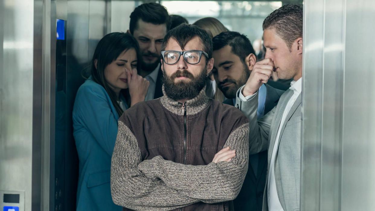 A dirty hipster affecting his coworkers in an elevator.