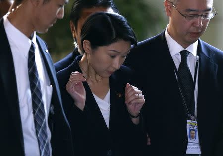 Japan's Economy, Trade and Industry Minister Yuko Obuchi (C) reacts as she is surrounded by reporters upon her arrival at Prime Minister Shinzo Abe's official residence for a meeting with Abe in Tokyo October 20, 2014. REUTERS/Issei Kato