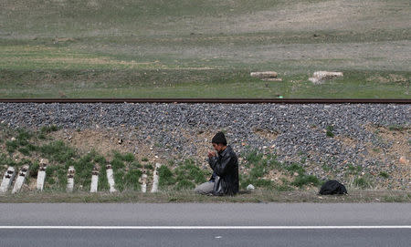 An Afghan migrant prays during a break from his walk along a main road after crossing the Turkey-Iran border near Erzurum, eastern Turkey, April 12, 2018. Picture taken April 12, 2018. REUTERS/Umit Bektas