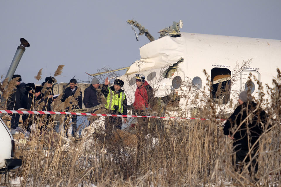 Rescuers assist on the site of a plane which crashed near Almaty International Airport, outside Almaty, Kazakhstan, Friday, Dec. 27, 2019. The Kazakhstan plane with 98 people aboard crashed shortly after takeoff early Friday. (AP Photo/Vladimir Tretyakov)