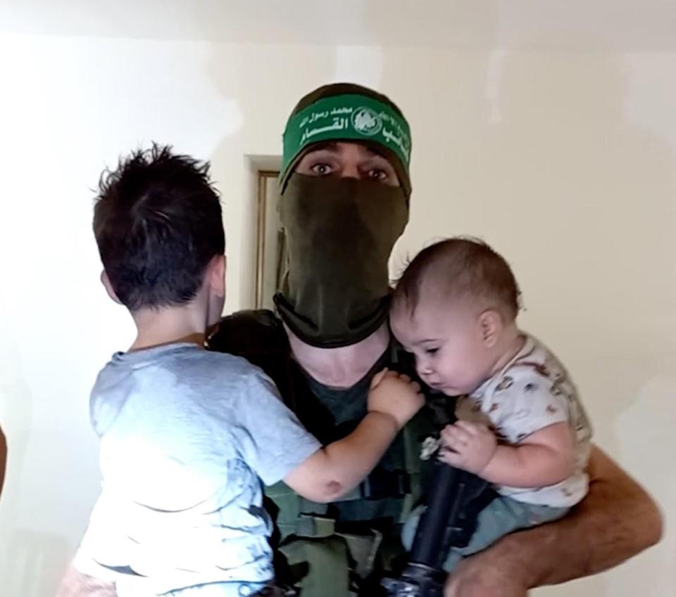 哈瑪斯公布一段武裝成員哄抱以色列幼童的影片，宣稱不會殺害兒童。翻攝網路
