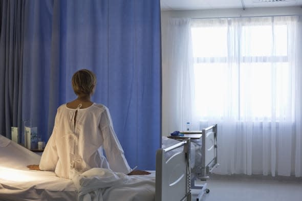 Patient wearing gown on hospital bed