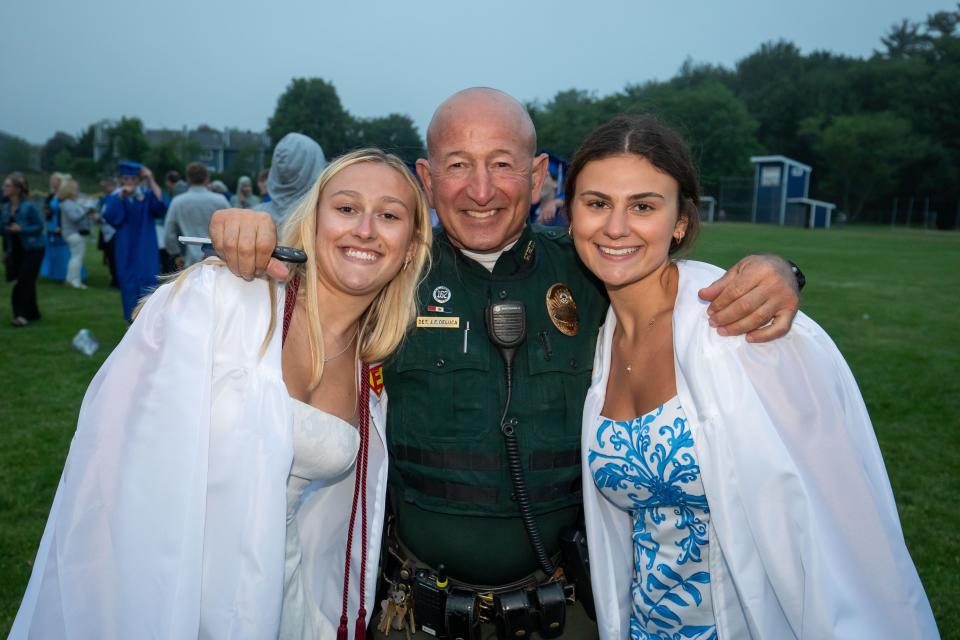 School Resource Officer James Deluca poses with graduates Alicia Lewis and Emma Cora at Winnacunnet High School's Class of 2024 graduation ceremony on Friday, June 7, 2024.