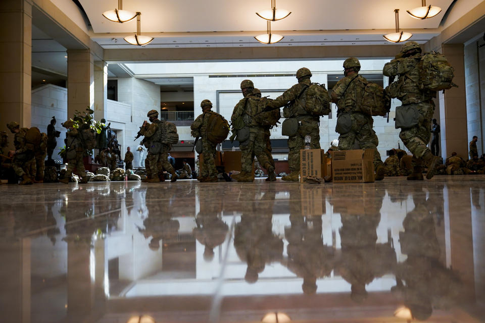 Troops move inside the Capitol Visitor's Center to reinforce security at the Capitol in Washington, Wednesday, Jan. 13, 2021. The House of Representatives is pursuing an article of impeachment against President Donald Trump for his role in inciting an angry mob to storm the Capitol last week. (AP Photo/Alex Brandon)