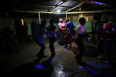 Residents dance at a bar in Boucan Ferdinand, Haiti, April 8, 2018. Sunday evening is the only time when the bar is open and residents gather there to socialise and dance. REUTERS/Andres Martinez Casares